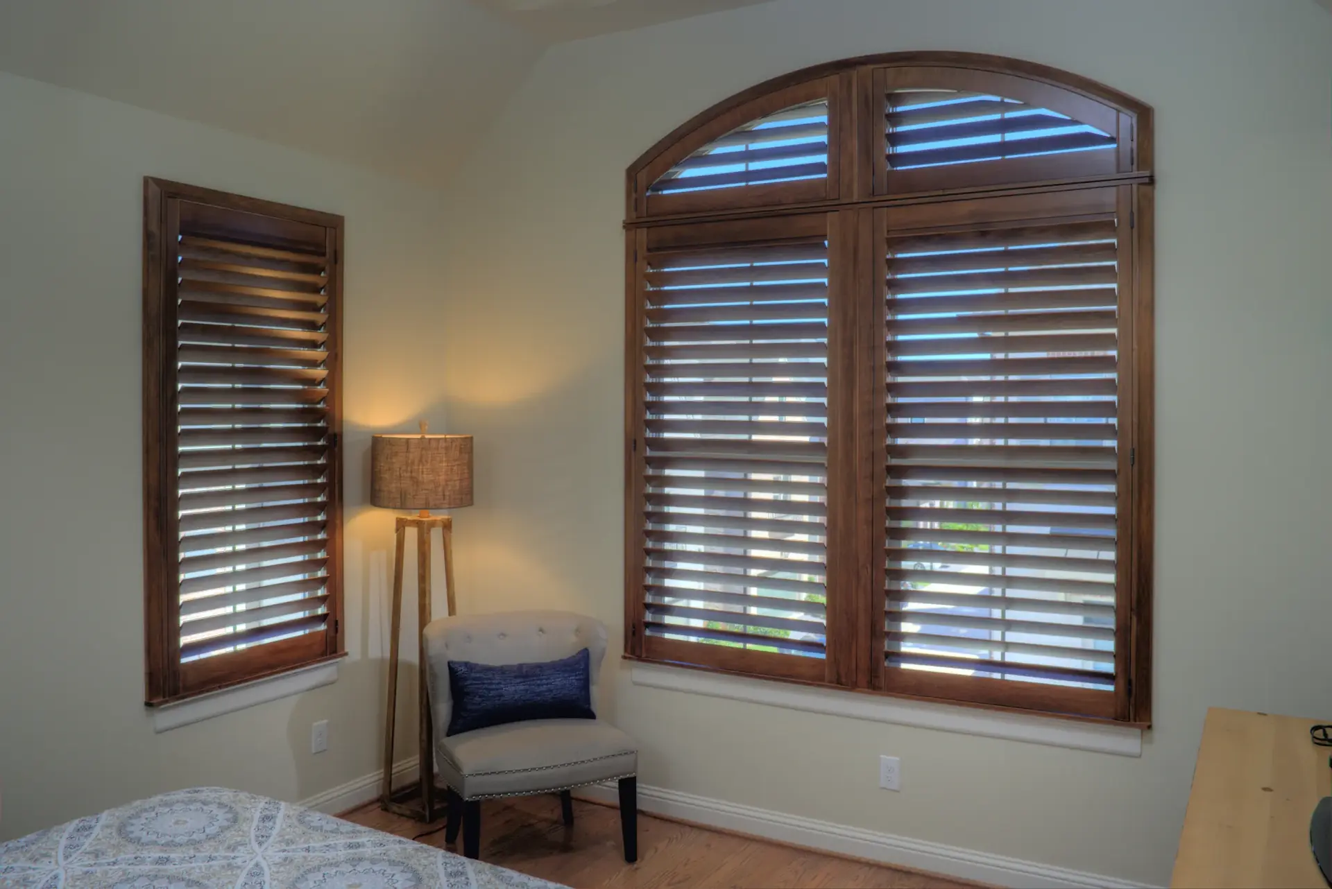 Arched windows with stained wood shutters
