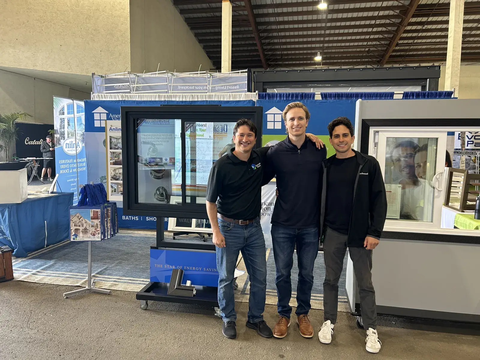Three team members standing in front of a window display